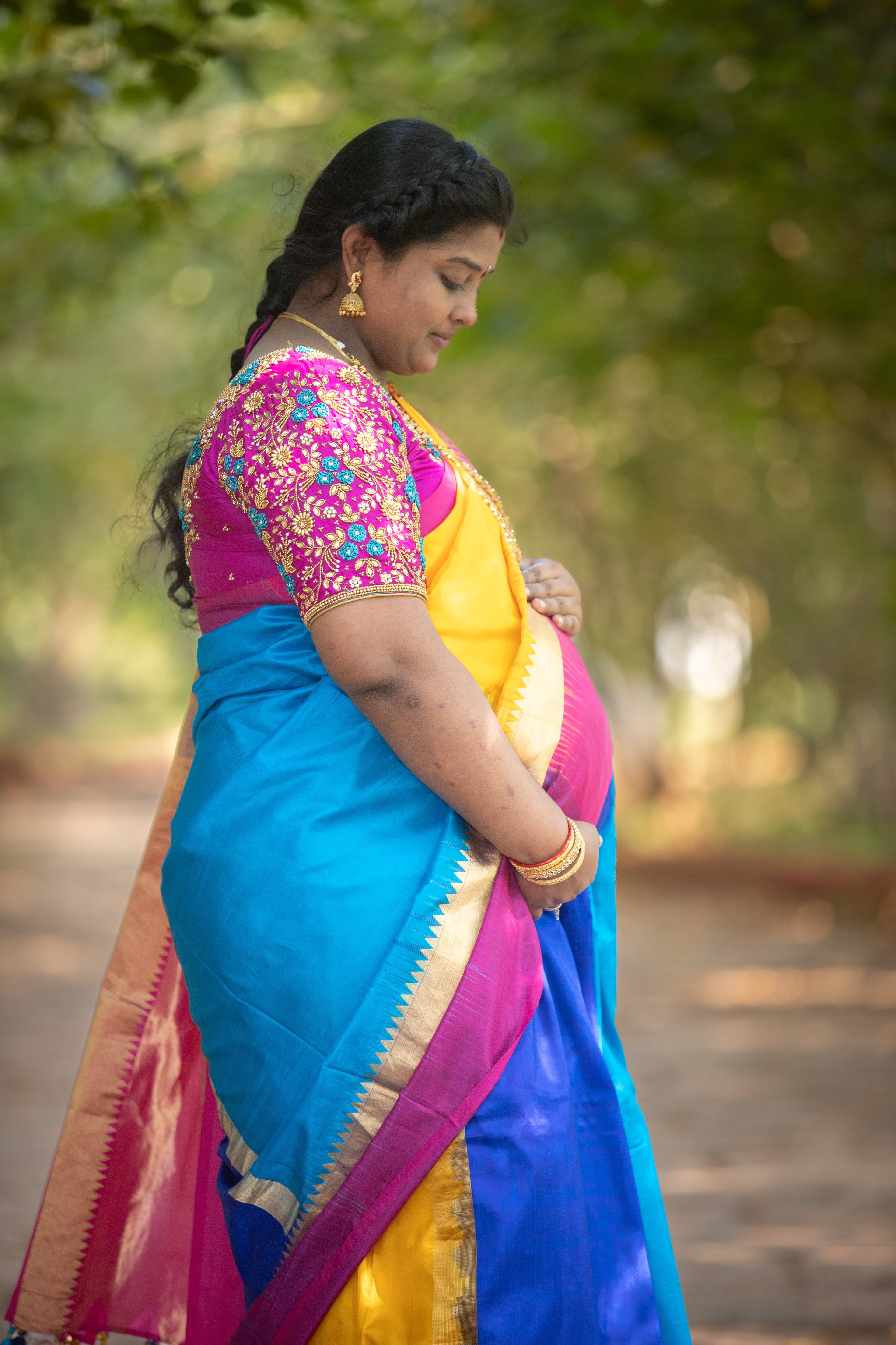 Pregnant woman in vibrant colorful traditional saree