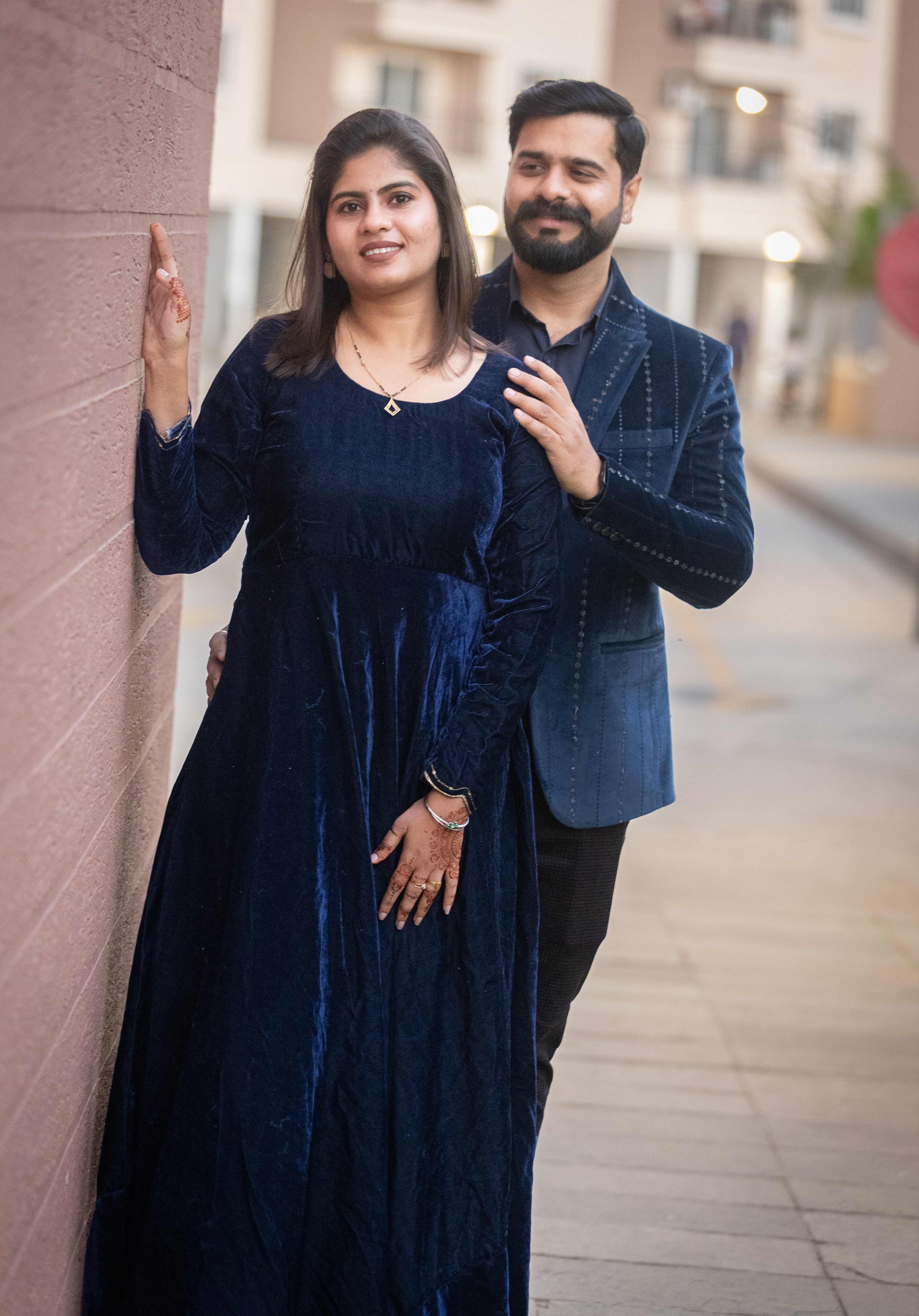 Stylish couple in formal attire against brick wall